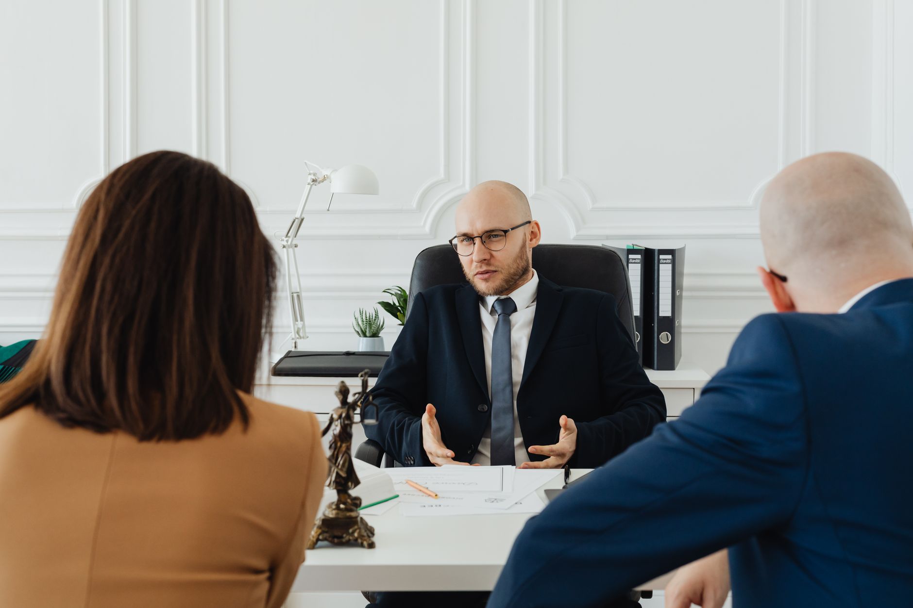 A loan officer explaining options to a young couple at a desk