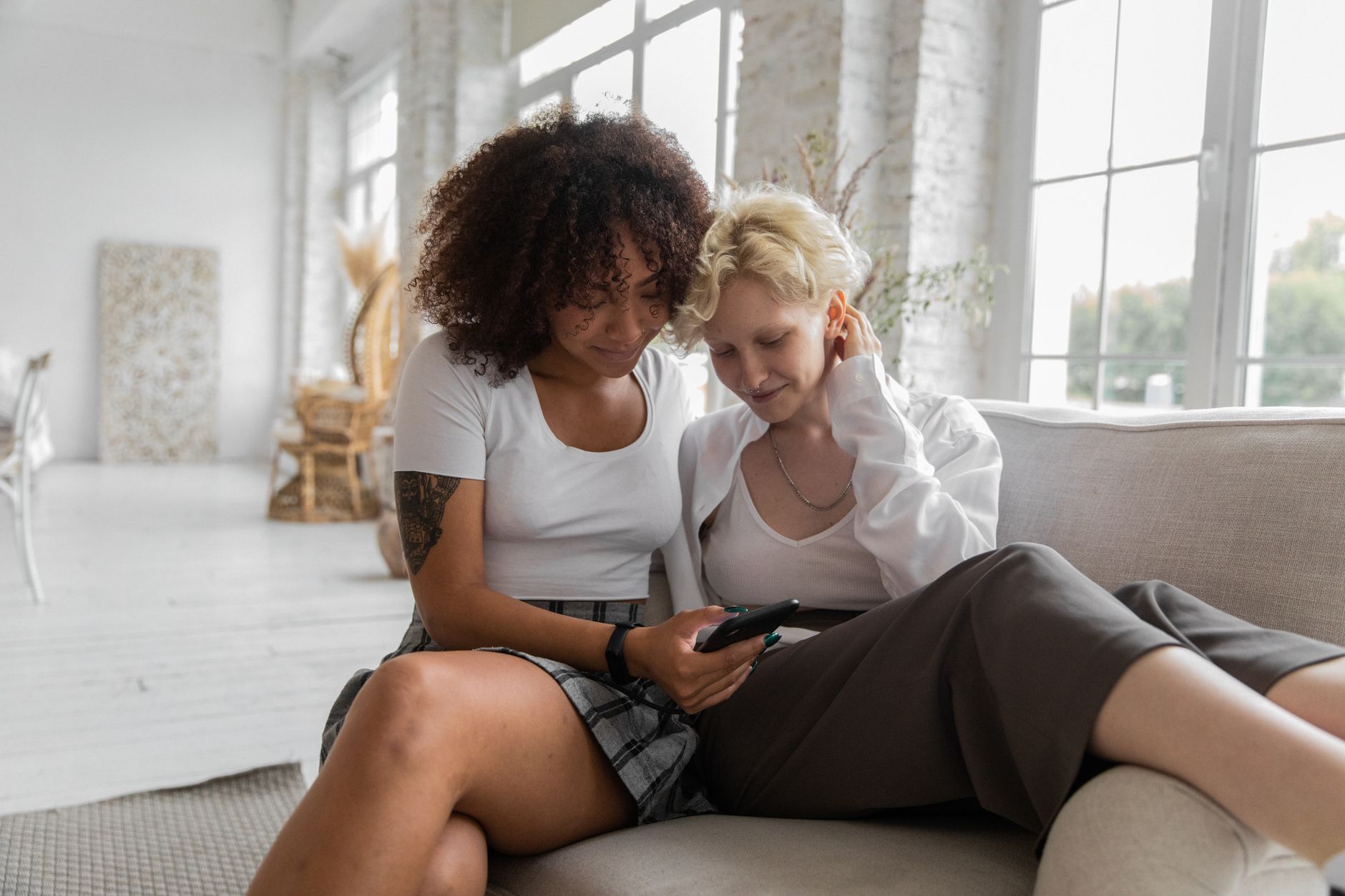A couple reading a text message about homes on their phone